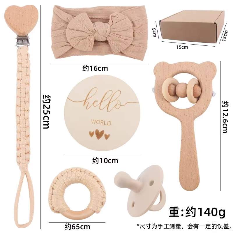 Detailaufnahme der Babygeschenk-Box mit naturfarbenem Beißring, weicher Rassel, Schnullerkette und Stoff-Stirnband