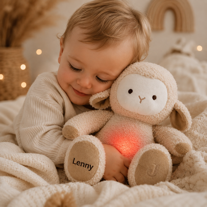     Baby kuschelt mit personalisiertem Kuscheltier Schaf mit leuchtendem Bauch.