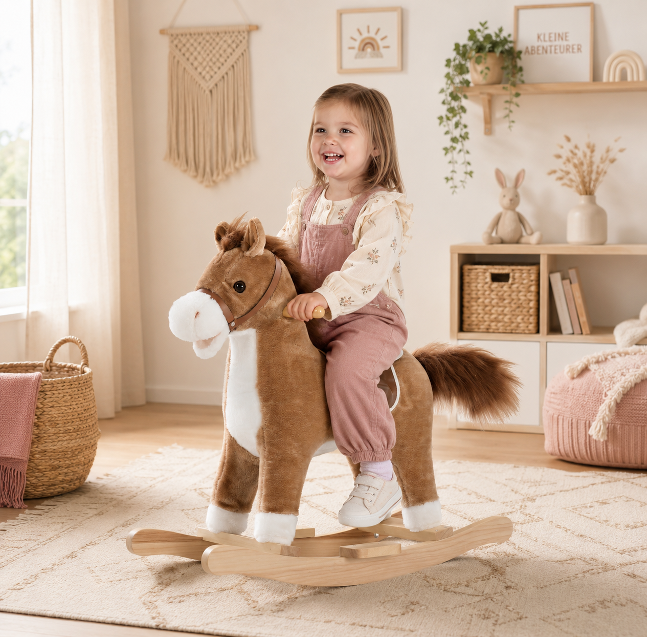 Kind sitzt auf braunem Schaukelpferd im hellen Boho Kinderzimmer in Beige und Naturtönen