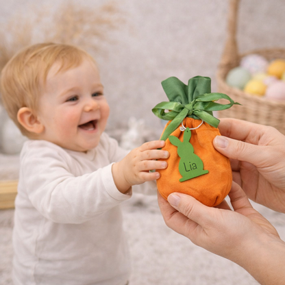 Kind erhält personalisiertes Oster-Geschenksäckchen als Möhre – kleines Osterbeutel mit Name auf dem Holzanhänger