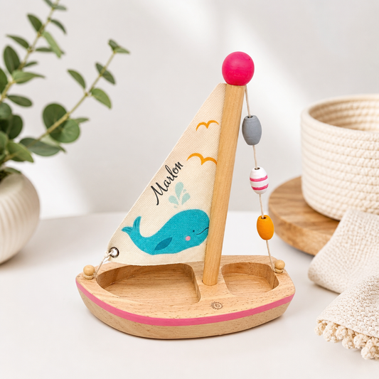 Personalisierbares Holzspielzeug Segelboot mit Namen und Wal-Motiv in minimalistischem, hellem Studio-Setup für Babygeschenke