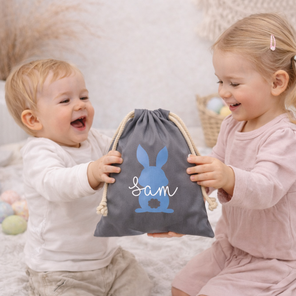 Zwei Kinder tauschen personalisierte Osterbeutel im Boho-Kinderzimmer