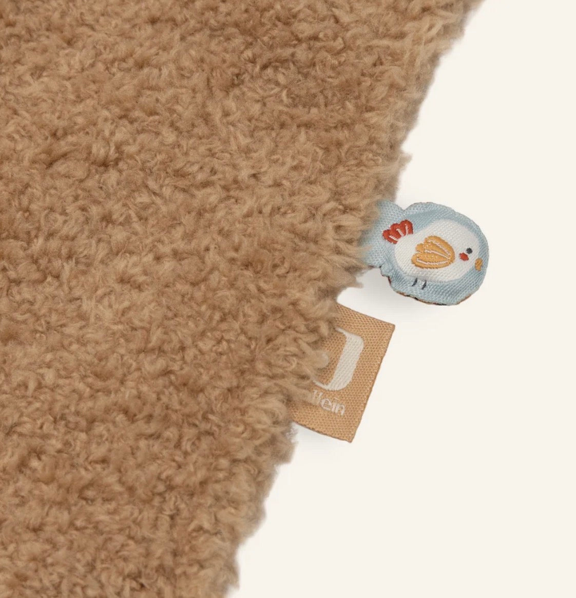 Detailaufnahme des weichen Bouclé-Stoffs und der Spielelemente am Jollein Schmusetuch