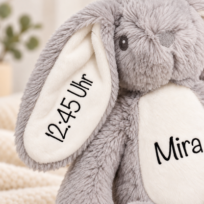 Detailfoto des grauen Kuschelhasen: Ohr mit Geburtszeit 12:45 Uhr und Name Mira auf dem Bauch – Gestaltungsbeispiel