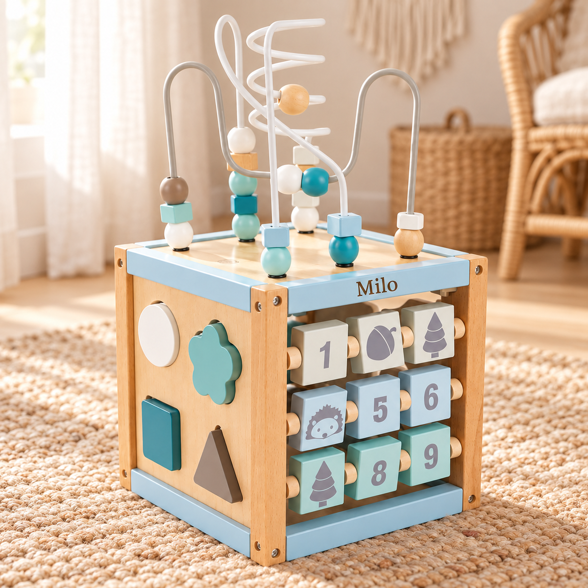 Blauer Motorikwürfel aus Holz mit Motorikschleife, Steckformen und Namensgravur „Milo“ in einem Kinderzimmer im Boho-Stil
